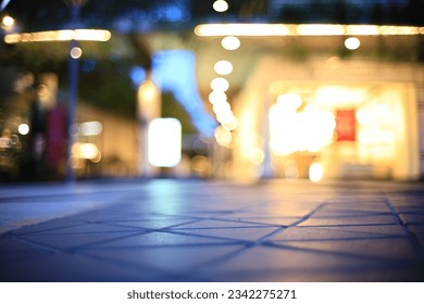 abstract blur outdoor shopping avenue at twilight for background, selective focus on floor pattern