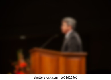 Abstract Blur Of Pastor Preaching Sermon At Church Background. 