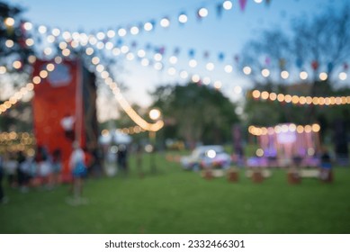 Abstract blur people in night outdoor festival city park bokeh background. Outdoor festive, party, celebration season concept.