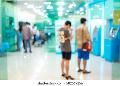 Abstract Blur People Queuing To Withdraw Money From ATM In The Bank.