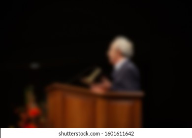 Abstract Blur Of Preacher Preaching Inside A Church From Podium. 