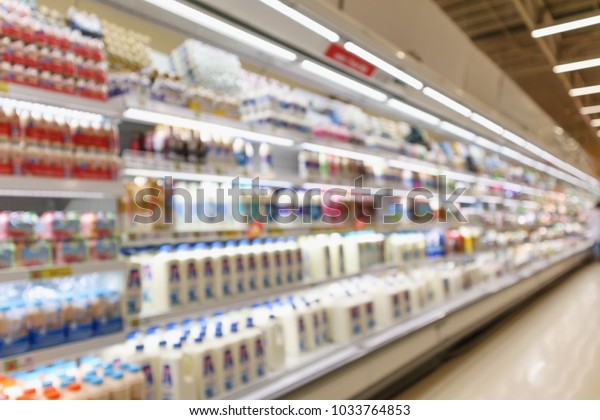 Abstract blur supermarket\
grocery store refrigerator shelves with fresh milk bottles and\
dairy products