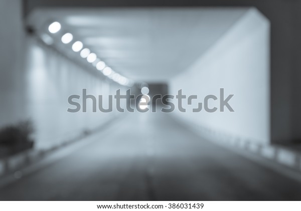 Abstract blur of traffic tunnel with headlight\
from motorcycle. Light at the end of tunnel and exit from darkness.\
Conceptual picture of Hope, future, freedom, progress, achievement,\
and life motion.