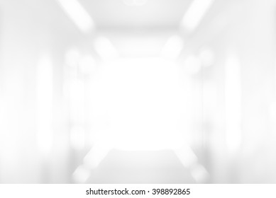 Abstract Blur White Empty Interior Room Or Blurred Corridor With Light At The End Wall, Background Or Backdrop For Presentation And Design Decoration In Hospital Building Or Modern Gallery Space