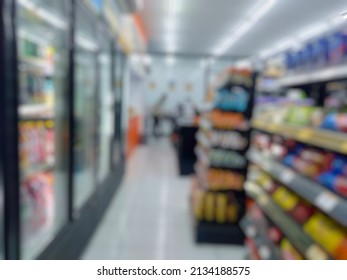 Abstract Blurred Background Of Aisle  With Variety Of Snacks And Drinks Corner On The Shelves In Minimarket Or Retail Store.