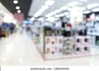 Abstract Blurred Background Of An Electronic Department Store Interior. Blur Aisle Of Supermarket Or Warehouse For Backdrop And Design Element Use. Defocused Background With Bokeh Light.