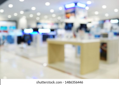 Abstract Blurred Background Of An Electronic Department Store Interior. Blur Aisle Of Supermarket Or Warehouse For Backdrop And Design Element Use. Defocused Background With Bokeh Light.