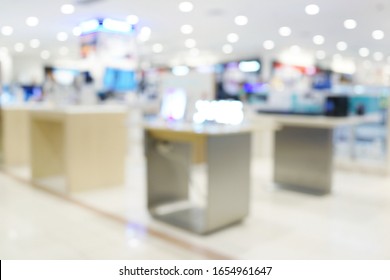 Abstract Blurred Background Of An Electronic Department Store Interior. Blur Aisle Of Supermarket Or Warehouse For Backdrop And Design Element Use. Defocused Background With Bokeh Light.