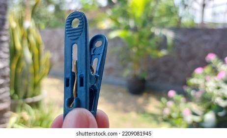 abstract. blurred background of hands holding clothespins in blue. clothespins made of plastic