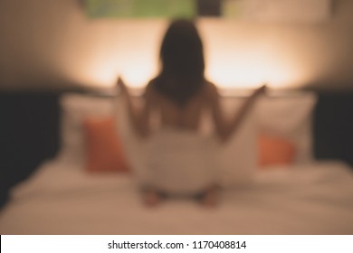 Abstract of blurred background image of Prostitution woman sitting on the bed in hotel waiting for her customer. Conceptual image of Sexual services or Sex tourism.