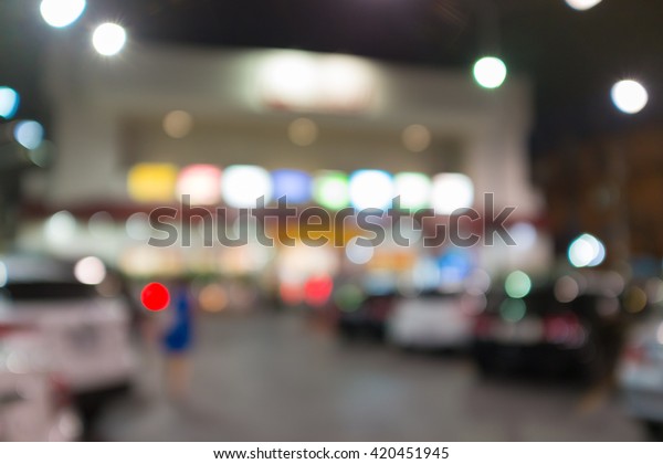 Abstract blurred background of outdoor parking\
lot in front of building night\
time
