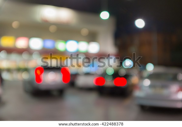 Abstract blurred background of outdoor parking\
lot in fornt of building night\
time
