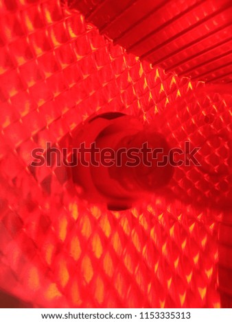 Abstract Blurred background of the Red Car Lamp. The Glass texture. Abstract out of focus lights coming from the Red Car Lamp. Abstract background of Red color. Close up. Macro. 