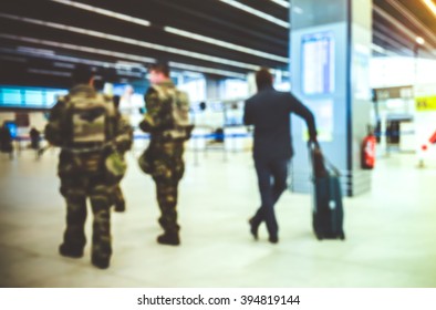 Abstract Blurred Background : Soldiers On Patrol In Airport Terminal For Vigipirate Plan Against Terrorism In France. Airline Passenger With Luggage Watch A Flight Information Board. Security Concept
