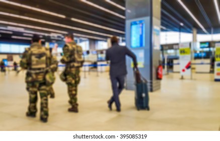 Abstract Blurred Background : Soldiers On Patrol In Airport Terminal Or Train Station Against Terrorism. Airline Passenger With Luggage Watch A Flight Information Board. Security, Terrorism Concept
