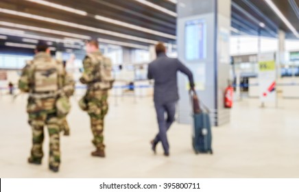 Abstract Blurred Background : Soldiers On Patrol In Airport Terminal Or Train Station Against Terrorism. Airline Passenger With Luggage Watch A Flight Information Board. Security, Terrorism Concept
