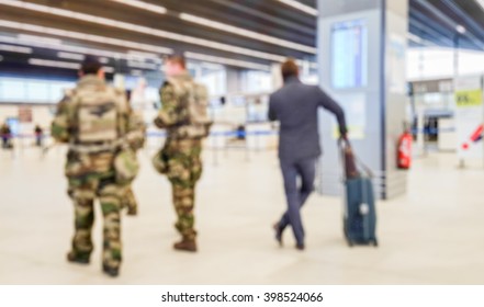 Abstract Blurred Background : Soldiers On Patrol In Airport Terminal Or Train Station Against Terrorism. Airline Passenger With Luggage Watch A Flight Information Board. Security, Terrorism Concept
