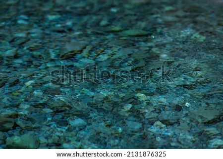 abstract blurred background - surface of a transparent clean blue water with circles from drops