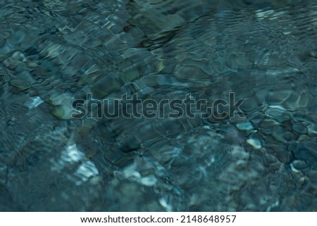 abstract blurred background - the surface of a transparent clean reservoir with circles from drops