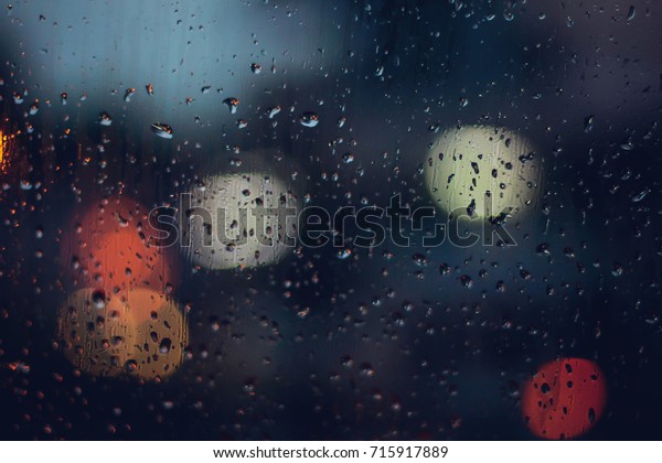 abstract blurred background traffic jam bokeh light view\
outside road from inside a car while raining with rain drops on\
glass, night cityscape,cinematic photography with film grain style\
