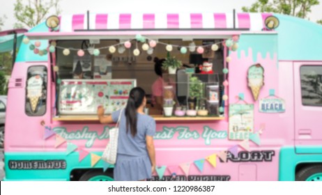 abstract blurred background of young women buying homemade yogurt, ice cream and dessert from beautiful vintage sweet pastel color food truck at the street food festival