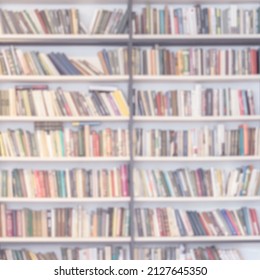 Abstract Blurred Bookshelves With Books, Manuals And Textbooks In Library, Book Store, At Home, For Light Backdrop. Concept Of Learning, School, Back To School, Education