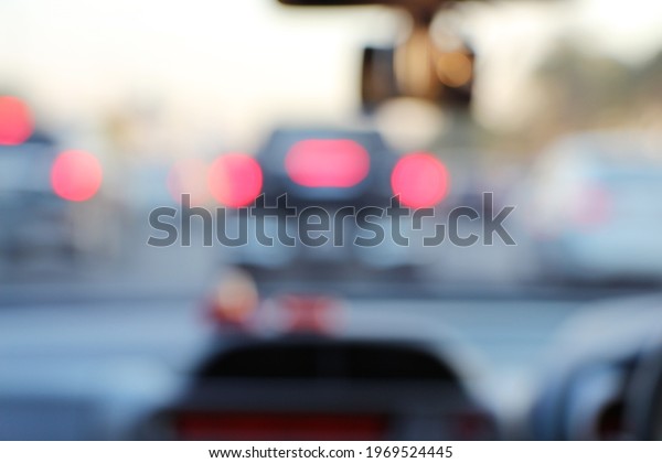 Abstract blurred of brake\
light of the car while the traffic jam on the road. View from\
inside car.