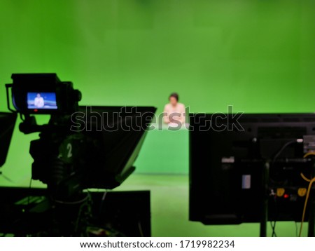 abstract blurred of broadcast camera in studio with virtual greenscreen at TV station.