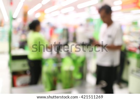 abstract blurred cashier at a supermarket checkout in a department store.
