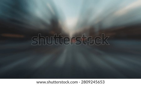 An abstract blurred cityscape with dramatic light rays emanating from the center, creating a sense of movement and energy.
