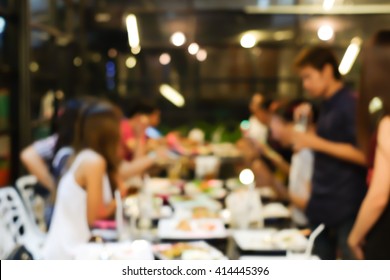 Abstract Blurred Group Of Asian Casual Family Meeting In The Restaurant Background At Night.