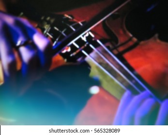 abstract blurred image. Actor violinist playing the violin strings. Musician plays a musical instrument on the concert stage.                                
