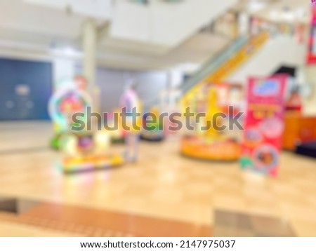 abstract blurred image of arcade game machine inside modern shopping mall. Bokeh image of the game zone area for background usage. Vintage tone effect image.

