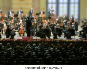 Abstract Blurred Image. Artists Symphony Orchestra. Musician Plays A Musical Instrument On The Concert Stage.  