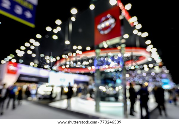 Abstract blurred image of cars exhibition show.\
Blur background of international motorshow, Bangkok , Thailand. car\
show room. Abstract blurred image of people in big events,\
international cars\
show.