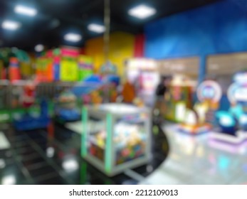 Abstract Blurred Image Of Game Zone Indoor. Bokeh Arcade Game Machine Inside Modern Shopping Mall 