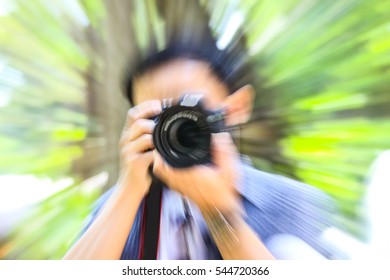 Abstract blurred image of a man taking photo at a park