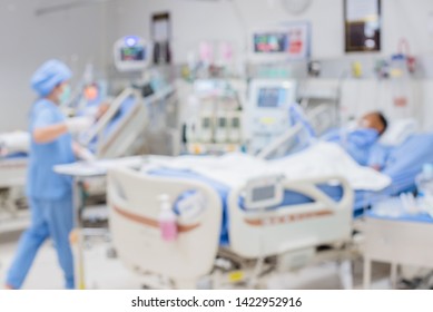 Abstract Blurred Image Of Nurse Changes Of Dressing On Male Patient Arm In Sickbed At Recovery Room Of Hospital For Background Design In Medical And Health Care Concept