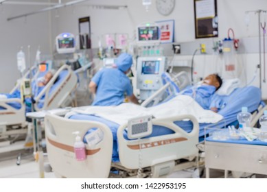 Abstract Blurred Image Of Nurse Changes Of Dressing On Male Patient Arm In Sickbed At Recovery Room Of Hospital For Background Design In Medical And Health Care Concept