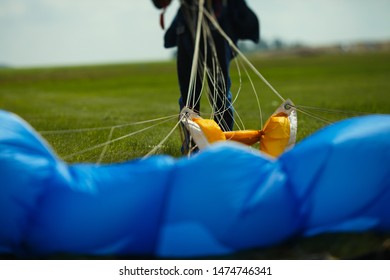 Abstract blurred image of a parachute canopy against the silhouette of a skydiver after landing, closeup.