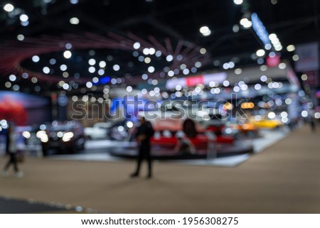 Abstract blurred image of people in cars exhibition show including activities and innovative automotive exhibitions at display. Blurred for background concept.