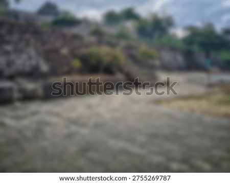 Abstract, blurred image of a stone pathway and retaining wall suggests a moody outdoor natural setting.