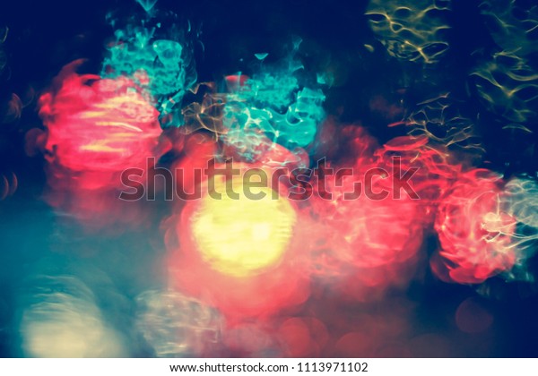 Abstract blurred Light traffic jam bokeh from\
inside a car view to outside road background while raining with\
rain drops on glass, night cityscape,cinematic photography vintage\
with film grain style.