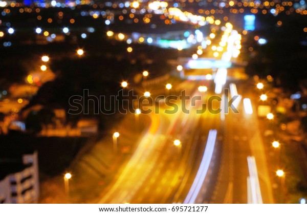 Abstract blurred lights highway with city\
downtown background