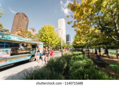 Abstract blurred motion food truck vendor customers buy and taste variety of foods. People waiting, queuing in line to pick up lunch and drink delivery at urban park in Dallas, Texas, USA, blue sky - Powered by Shutterstock