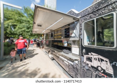 Abstract Blurred Motion Food Truck Vendor Customers Buy And Taste Variety Of Foods. People Waiting, Queuing In Line To Pick Up Lunch And Drink Delivery At Urban Park In Dallas, Texas, USA, Blue Sky