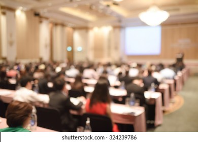 Abstract Blurred People In Big Meeting Or Conference Room For Background. Warm Tone Photo.