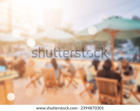 Abstract blurred of people are sitting in an outdoor cafe. Cafe with lots of visitors.