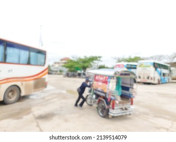 Abstract blurred photo of a tricycle driver is moving his car into a parking lot in the bus station.