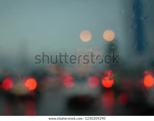 abstract blurred of rain water drops on the\
windshield in a rainy\
day.
